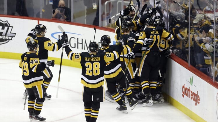 Feb 15, 2022; Pittsburgh, Pennsylvania, USA;  Pittsburgh Penguins center Sidney Crosby (hiden) is mobbed by teammates after Crosby scored his 500th career NHL goal against the Philadelphia Flyers during the first period at PPG Paints Arena. Mandatory Credit: Charles LeClaire-USA TODAY Sports