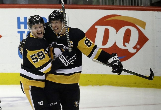 Feb 15, 2022; Pittsburgh, Pennsylvania, USA;  Pittsburgh Penguins left wing Jake Guentzel (59) congratulates center Sidney Crosby (87) after Crosby scored his 500th career NHL goal against the Philadelphia Flyers during the first period at PPG Paints Arena. Mandatory Credit: Charles LeClaire-USA TODAY Sports