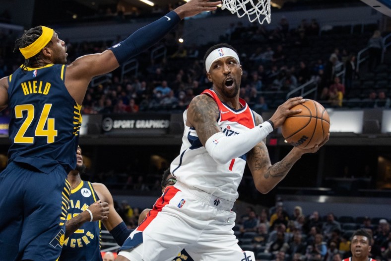 Feb 16, 2022; Indianapolis, Indiana, USA; Washington Wizards guard Kentavious Caldwell-Pope (1) jumps with the ball while Indiana Pacers guard Buddy Hield (24) defends in the first half at Gainbridge Fieldhouse. Mandatory Credit: Trevor Ruszkowski-USA TODAY Sports