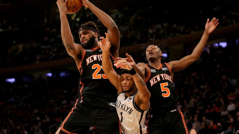 Feb 16, 2022; New York, New York, USA; New York Knicks center Mitchell Robinson (23) grabs a rebound against Brooklyn Nets forward Bruce Brown (1) in front of Knicks guard Immanuel Quickley (5) during the second quarter at Madison Square Garden. Mandatory Credit: Brad Penner-USA TODAY Sports