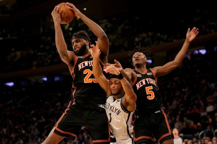 Feb 16, 2022; New York, New York, USA; New York Knicks center Mitchell Robinson (23) grabs a rebound against Brooklyn Nets forward Bruce Brown (1) in front of Knicks guard Immanuel Quickley (5) during the second quarter at Madison Square Garden. Mandatory Credit: Brad Penner-USA TODAY Sports