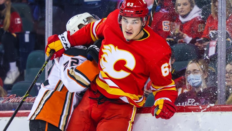 Feb 16, 2022; Calgary, Alberta, CAN; Calgary Flames center Adam Ruzicka (63) checks into the boards Anaheim Ducks defenseman Kevin Shattenkirk (22) during the first period at Scotiabank Saddledome. Mandatory Credit: Sergei Belski-USA TODAY Sports