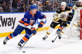 Feb 17, 2022; Elmont, New York, USA;  New York Islanders center Mathew Barzal (13) brings the puck put from behind the net chased by Boston Bruins center Charlie Coyle (13) during the second period at UBS Arena. Mandatory Credit: Dennis Schneidler-USA TODAY Sports