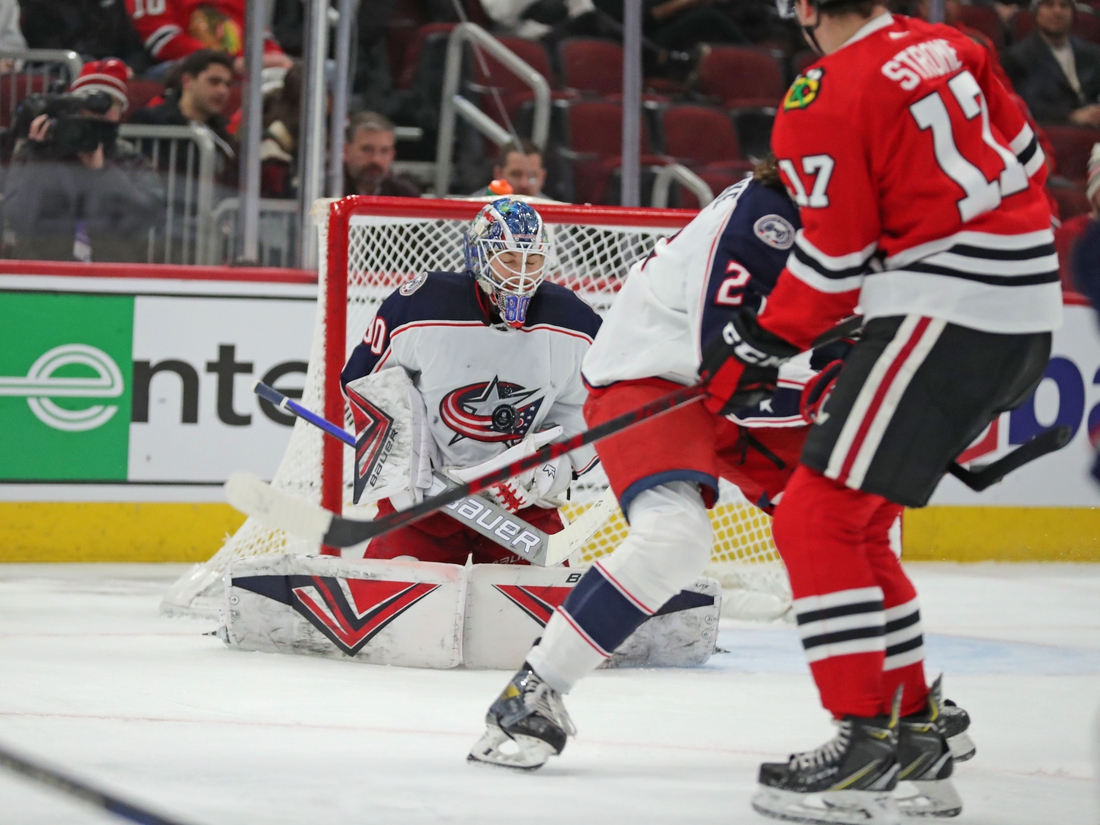 Feb 17, 2022; Chicago, Illinois, USA; Columbus Blue Jackets goaltender Elvis Merzlikins (90) makes a save on a tip from Chicago Blackhawks center Dylan Strome (17) during the first period at the United Center. Mandatory Credit: Dennis Wierzbicki-USA TODAY Sports