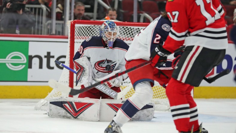 Feb 17, 2022; Chicago, Illinois, USA; Columbus Blue Jackets goaltender Elvis Merzlikins (90) makes a save on a tip from Chicago Blackhawks center Dylan Strome (17) during the first period at the United Center. Mandatory Credit: Dennis Wierzbicki-USA TODAY Sports