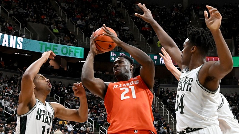 Feb 19, 2022; East Lansing, Michigan, USA; Illinois Fighting Illini center Kofi Cockburn (21) grabs a rebound in the first half against Michigan State Spartans guard A.J. Hoggard (11) and forward Julius Marble II (34) at Jack Breslin Student Events Center. Mandatory Credit: Dale Young-USA TODAY Sports