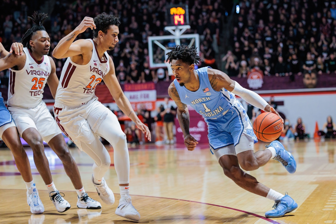 Feb 19, 2022; Blacksburg, Virginia, USA; North Carolina Tar Heels forward Leaky Black (1) drives past Virginia Tech Hokies forward Keve Aluma (22) during the first half at Cassell Coliseum. Mandatory Credit: Ryan Hunt-USA TODAY Sports