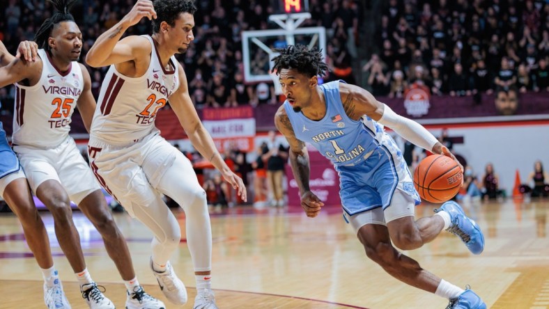 Feb 19, 2022; Blacksburg, Virginia, USA; North Carolina Tar Heels forward Leaky Black (1) drives past Virginia Tech Hokies forward Keve Aluma (22) during the first half at Cassell Coliseum. Mandatory Credit: Ryan Hunt-USA TODAY Sports