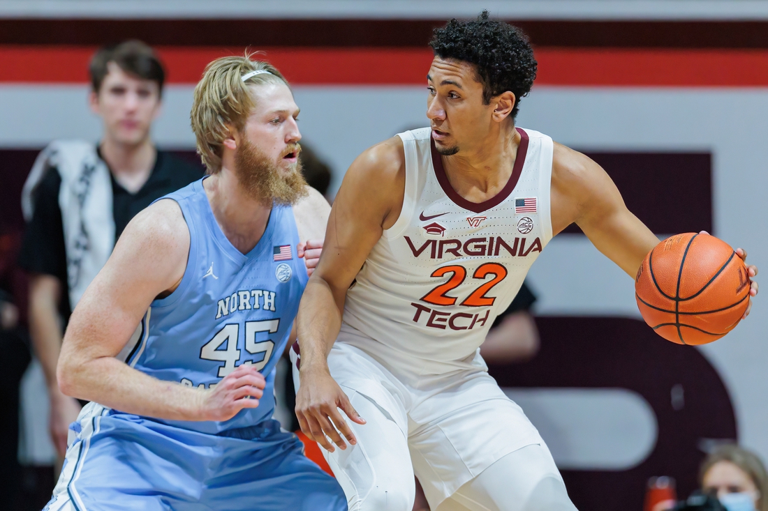 Feb 19, 2022; Blacksburg, Virginia, USA; Virginia Tech Hokies forward Keve Aluma (22) is defended by North Carolina Tar Heels forward Brady Malek (45) during the first half at Cassell Coliseum. Mandatory Credit: Ryan Hunt-USA TODAY Sports