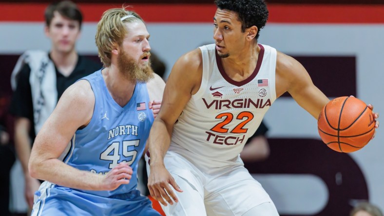 Feb 19, 2022; Blacksburg, Virginia, USA; Virginia Tech Hokies forward Keve Aluma (22) is defended by North Carolina Tar Heels forward Brady Malek (45) during the first half at Cassell Coliseum. Mandatory Credit: Ryan Hunt-USA TODAY Sports