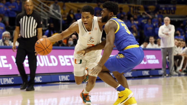 Feb 22, 2022; Pittsburgh, Pennsylvania, USA; Miami (Fl) Hurricanes guard Charlie Moore (3) dribbles the ball against Pittsburgh Panthers guard Onyebuchi Ezeakudo (31) during the first half at the Petersen Events Center. Mandatory Credit: Charles LeClaire-USA TODAY Sports