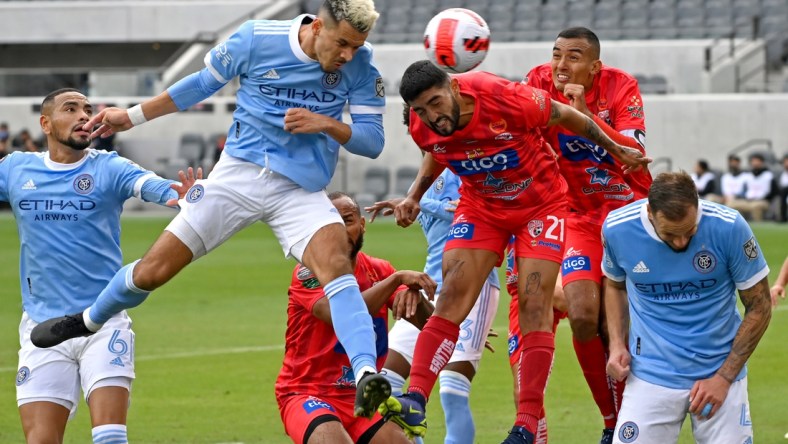 Feb 23, 2022; Los Angeles, CA, USA; New York City midfielder Alfredo Morales (7) heads the ball for a goal past Santos de Guapiles defender Everardo Rubio (21)during the first half of the game at Banc of California Stadium. Mandatory Credit: Jayne Kamin-Oncea-USA TODAY Sports