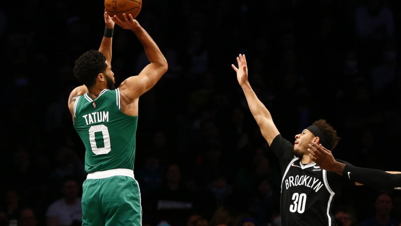 Feb. 24, 2022 ; Brooklyn, New York, USA; Boston Celtics forward Jayson Tatum (0) shoots while being defended by Brooklyn Nets guard Seth Curry (30) during the first half at Barclays Center. Mandatory Credit: Andy Marlin-USA TODAY Sports