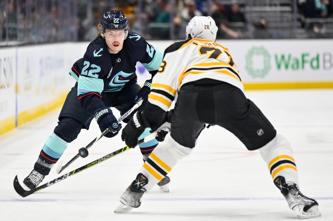 Feb 24, 2022; Seattle, Washington, USA; Seattle Kraken center Mason Appleton (22) advances the puck while being defended by Boston Bruins defenseman Derek Forbort (28) during the first period at Climate Pledge Arena. Mandatory Credit: Steven Bisig-USA TODAY Sports