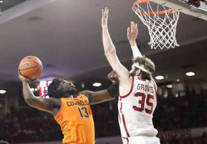 Feb 26, 2022; Norman, Oklahoma, USA; Oklahoma State Cowboys guard Isaac Likekele (13) goes to the basket as Oklahoma Sooners forward Tanner Groves (35) defends during the first half at Lloyd Noble Center. Mandatory Credit: Alonzo Adams-USA TODAY Sports