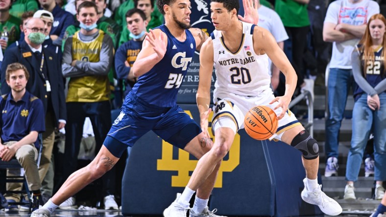 Feb 26, 2022; South Bend, Indiana, USA; Notre Dame Fighting Irish forward Paul Atkinson Jr. (20) dribbles as Georgia Tech Yellow Jackets center Rodney Howard (24) defends in the first half at the Purcell Pavilion. Mandatory Credit: Matt Cashore-USA TODAY Sports