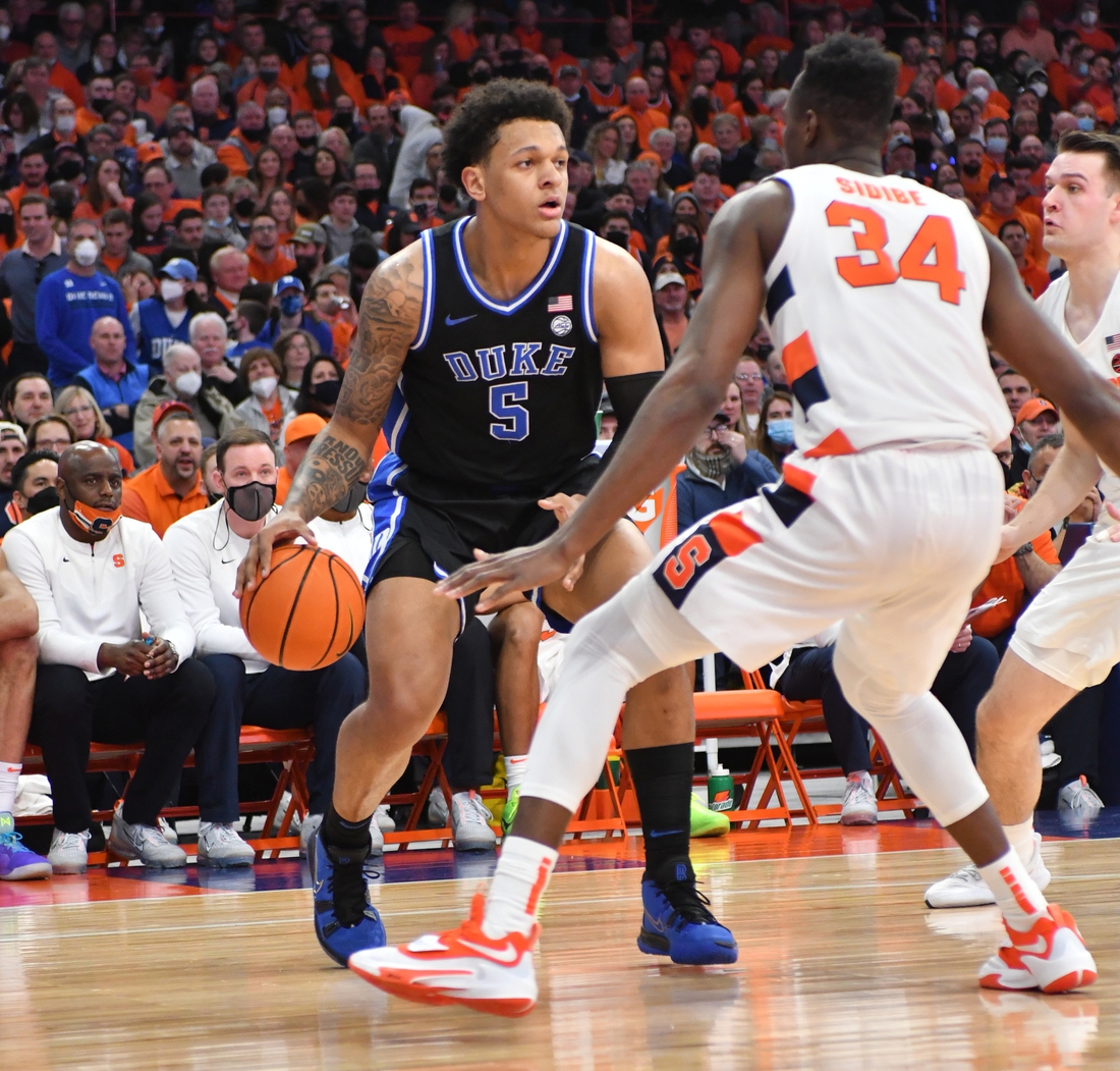 Feb 26, 2022; Syracuse, New York, USA; Duke Blue Devils forward Paolo Banchero (5) handles the ball as Syracuse Orange center Bourama Sidibe (34) defends in the first half at the Carrier Dome. Mandatory Credit: Mark Konezny-USA TODAY Sports