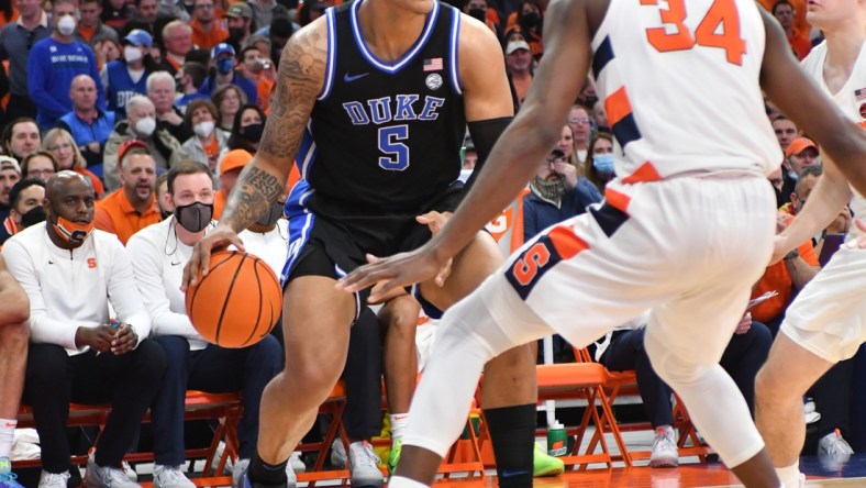 Feb 26, 2022; Syracuse, New York, USA; Duke Blue Devils forward Paolo Banchero (5) handles the ball as Syracuse Orange center Bourama Sidibe (34) defends in the first half at the Carrier Dome. Mandatory Credit: Mark Konezny-USA TODAY Sports