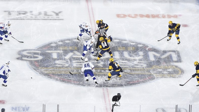 Feb 26, 2022; Nashville, Tennessee, USA; Nashville Predators left wing Tanner Jeannot (84) and Tampa Bay Lightning center Brayden Point (21) face off during the first in a Stadium Series ice hockey game at Nissan Stadium. Mandatory Credit: Steve Roberts-USA TODAY Sports