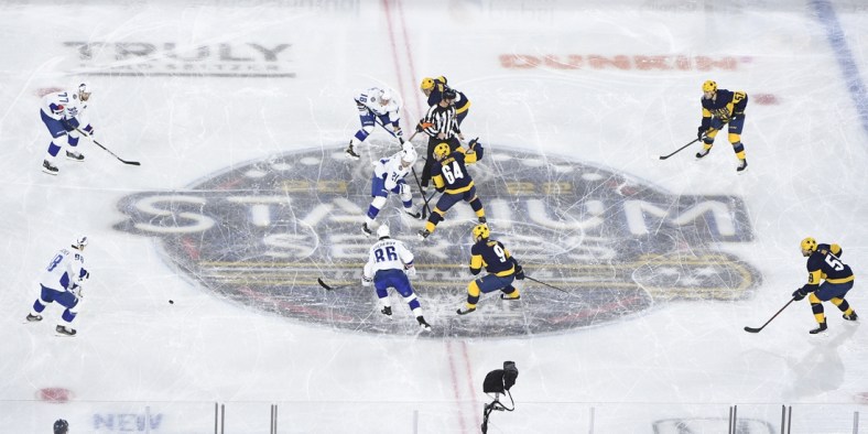 Feb 26, 2022; Nashville, Tennessee, USA; Nashville Predators left wing Tanner Jeannot (84) and Tampa Bay Lightning center Brayden Point (21) face off during the first in a Stadium Series ice hockey game at Nissan Stadium. Mandatory Credit: Steve Roberts-USA TODAY Sports