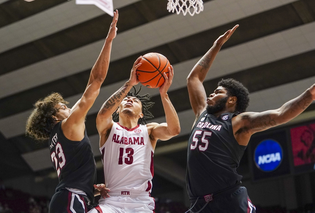 Feb 26, 2022; Tuscaloosa, Alabama, USA; Alabama Crimson Tide guard Jahvon Quinerly (13) goes to the basket against South Carolina Gamecocks guard Devin Carter (23) and forward Ta'Quan Woodley (55) during second half at Coleman Coliseum. Mandatory Credit: Marvin Gentry-USA TODAY Sports