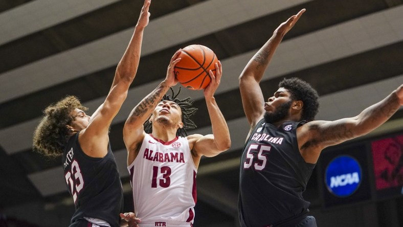 Feb 26, 2022; Tuscaloosa, Alabama, USA; Alabama Crimson Tide guard Jahvon Quinerly (13) goes to the basket against South Carolina Gamecocks guard Devin Carter (23) and forward Ta'Quan Woodley (55) during second half at Coleman Coliseum. Mandatory Credit: Marvin Gentry-USA TODAY Sports