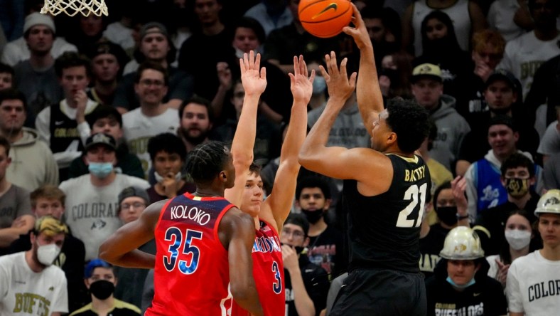 Feb 26, 2022; Boulder, Colorado, USA; Colorado Buffaloes forward Evan Battey (21) shoots over Arizona Wildcats guard Pelle Larsson (3) and center Christian Koloko (35) in the first half at the CU Events Center. Mandatory Credit: Ron Chenoy-USA TODAY Sports