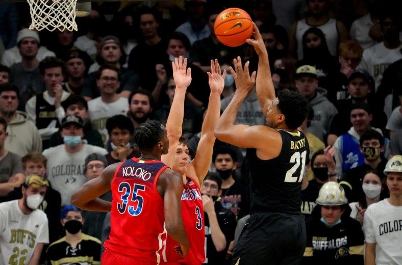 Feb 26, 2022; Boulder, Colorado, USA; Colorado Buffaloes forward Evan Battey (21) shoots over Arizona Wildcats guard Pelle Larsson (3) and center Christian Koloko (35) in the first half at the CU Events Center. Mandatory Credit: Ron Chenoy-USA TODAY Sports