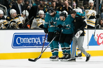 Feb 26, 2022; San Jose, California, USA; San Jose Sharks defenseman Mario Ferraro (38) is helped off the ice by defenseman Brent Burns (88) after suffering an apparent injury during the second period in the game against the Boston Bruins at SAP Center at San Jose. Mandatory Credit: John Hefti-USA TODAY Sports