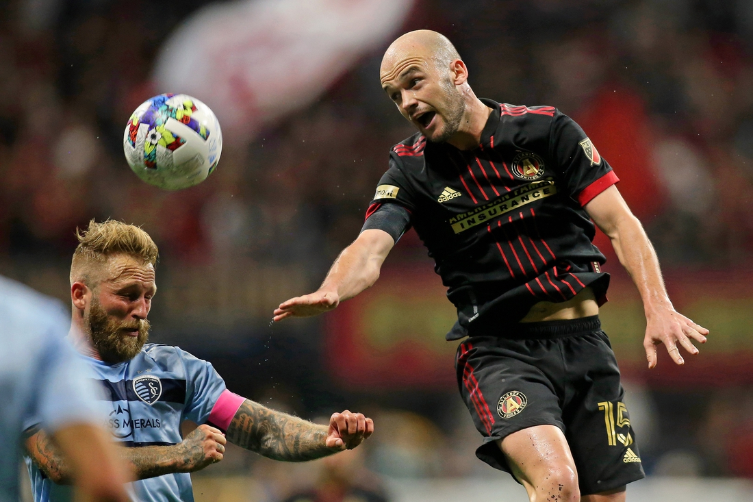 Feb 27, 2022; Atlanta, Georgia, USA; Sporting Kansas City midfielder Oriol Rosell (6) battles for the ball against Atlanta United defender Andrew Gutman (15) during the first half at Mercedes-Benz Stadium. Mandatory Credit: Brett Davis-USA TODAY Sports