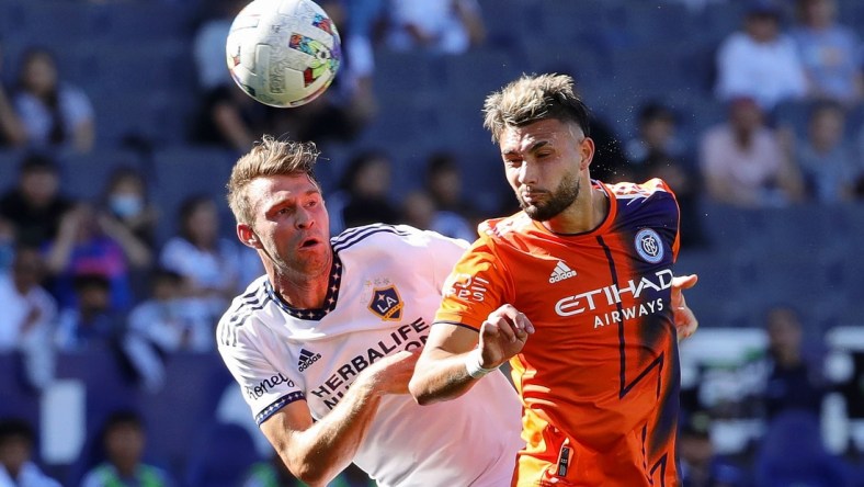 Feb 27, 2022; Carson, California, USA; Los Angeles Galaxy forward Nick DePuy (20) and New York City midfielder Valent n Castellanos (11) battle for the ball during the first half at Dignity Health Sports Park. Mandatory Credit: Kiyoshi Mio-USA TODAY Sports