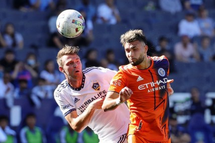 Feb 27, 2022; Carson, California, USA; Los Angeles Galaxy forward Nick DePuy (20) and New York City midfielder Valent n Castellanos (11) battle for the ball during the first half at Dignity Health Sports Park. Mandatory Credit: Kiyoshi Mio-USA TODAY Sports
