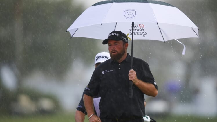 Feb 27, 2022; Palm Beach Gardens, Florida, USA; Shane Lowry holds an umbrella on the 18th green while it rains during the final round of The Honda Classic golf tournament. Mandatory Credit: Sam Navarro-USA TODAY Sports
