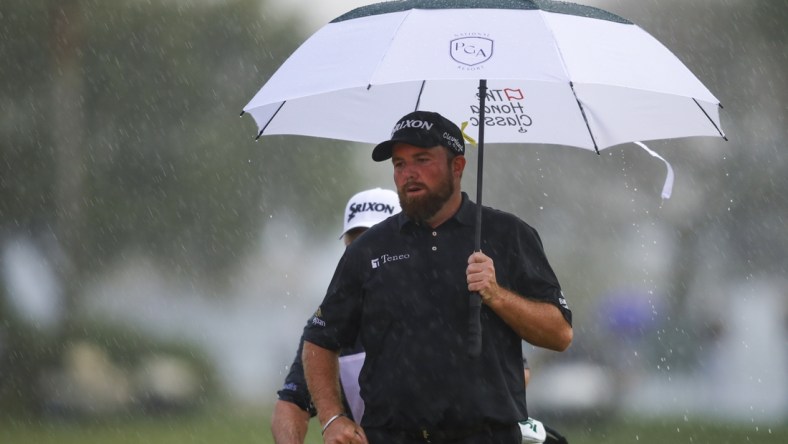 Feb 27, 2022; Palm Beach Gardens, Florida, USA; Shane Lowry holds an umbrella on the 18th green while it rains during the final round of The Honda Classic golf tournament. Mandatory Credit: Sam Navarro-USA TODAY Sports