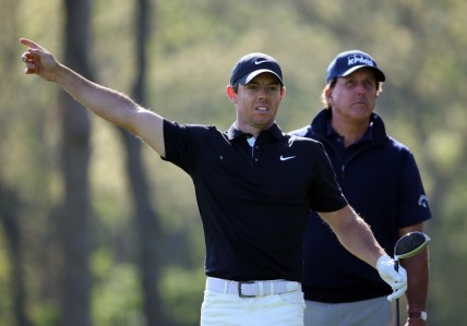 May 17, 2019; Bethpage, NY, USA; Rory McIlroy reacts after his shot from the 12th tee as Phil Mickelson (right) looks on during the second round of the PGA Championship golf tournament at Bethpage State Park - Black Course. Mandatory Credit: Peter Casey-USA TODAY Sports