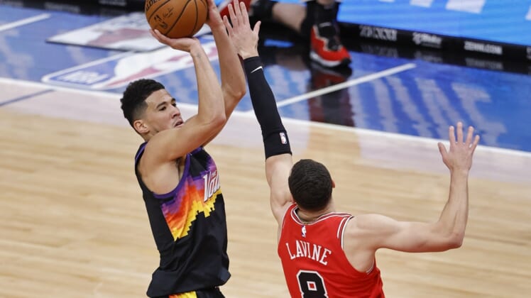 Feb 26, 2021; Chicago, Illinois, USA; Phoenix Suns guard Devin Booker (1) shoots against Chicago Bulls guard Zach LaVine (8) during the first half of an NBA game at United Center. Mandatory Credit: Kamil Krzaczynski-USA TODAY Sports