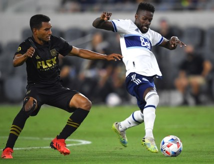 Jul 24, 2021; Los Angeles, CA, USA; Los Angeles FC defender Eddie Segura (4) and Vancouver Whitecaps forward Tosaint Ricketts (87) battle for the ball in the second half at Banc of California Stadium. Mandatory Credit: Jayne Kamin-Oncea-USA TODAY Sports