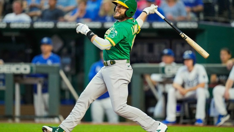 Sep 14, 2021; Kansas City, Missouri, USA; Oakland Athletics designated hitter Jed Lowrie (8) hits a sacrifice fly against the Kansas City Royals during the first inning at Kauffman Stadium. Mandatory Credit: Jay Biggerstaff-USA TODAY Sports