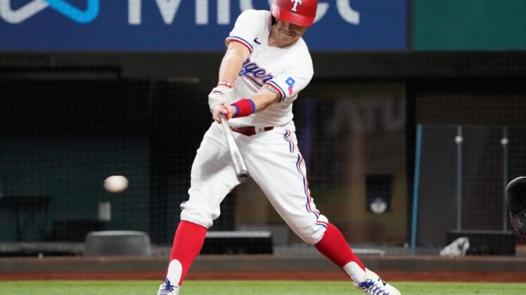 Oct 2, 2021; Arlington, Texas, USA; Texas Rangers third baseman Brock Holt (16) singles against the Cleveland Indians during the eighth inning at Globe Life Field. Mandatory Credit: Jim Cowsert-USA TODAY Sports