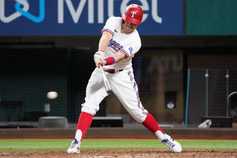 Oct 2, 2021; Arlington, Texas, USA; Texas Rangers third baseman Brock Holt (16) singles against the Cleveland Indians during the eighth inning at Globe Life Field. Mandatory Credit: Jim Cowsert-USA TODAY Sports