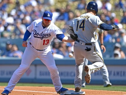 Oct 3, 2021; Los Angeles, California, USA;  Los Angeles Dodgers first baseman Max Muncy (13) makes a tag against Milwaukee Brewers second baseman Jace Peterson (14) on a throw from Dodgers shortstop Trea Turner (not pictured) in the third inning at Dodger Stadium. Muncy left the game with an apparent injury to his left arm. Mandatory Credit: Jayne Kamin-Oncea-USA TODAY Sports