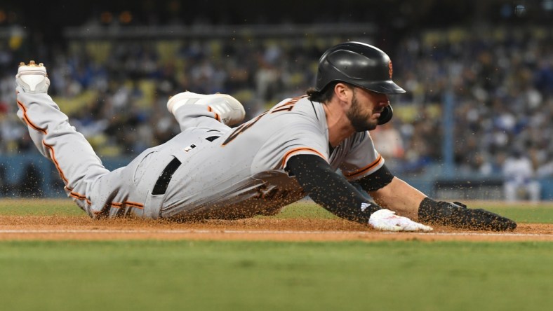 Oct 12, 2021; Los Angeles, California, USA; San Francisco Giants right fielder Kris Bryant (23) slides into third base during game four of the 2021 NLDS at Dodger Stadium. Mandatory Credit: Richard Mackson-USA TODAY Sports