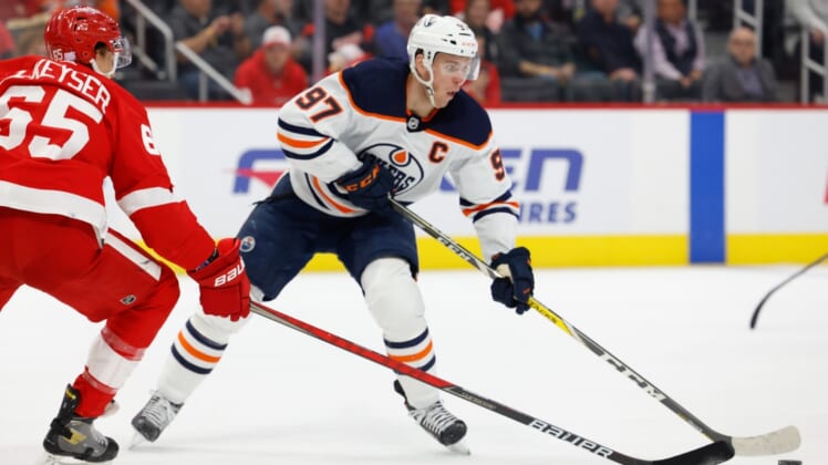 Nov 9, 2021; Detroit, Michigan, USA; Edmonton Oilers center Connor McDavid (97) skates with the puck defended by Detroit Red Wings defenseman Danny DeKeyser (65) in the first period at Little Caesars Arena. Mandatory Credit: Rick Osentoski-USA TODAY Sports