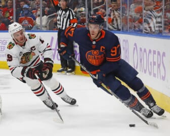Nov 20, 2021; Edmonton, Alberta, CAN; Chicago Blackhawks forward Jonathan Toews (19) chases Edmonton Oilers forward Connor McDavid (97) behind the net during the third period at Rogers Place. Mandatory Credit: Perry Nelson-USA TODAY Sports