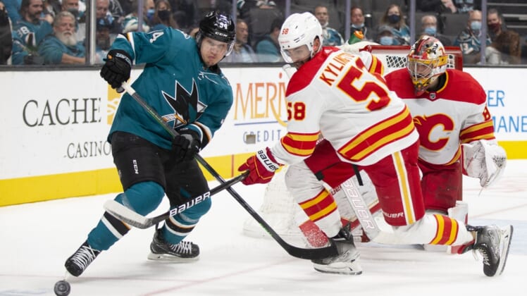 Dec 7, 2021; San Jose, California, USA; San Jose Sharks left wing Alexander Barabanov (94) and Calgary Flames defenseman Oliver Kylington (58) vie for the puck in front of the Calgary goal during the second period at SAP Center at San Jose. Mandatory Credit: D. Ross Cameron-USA TODAY Sports