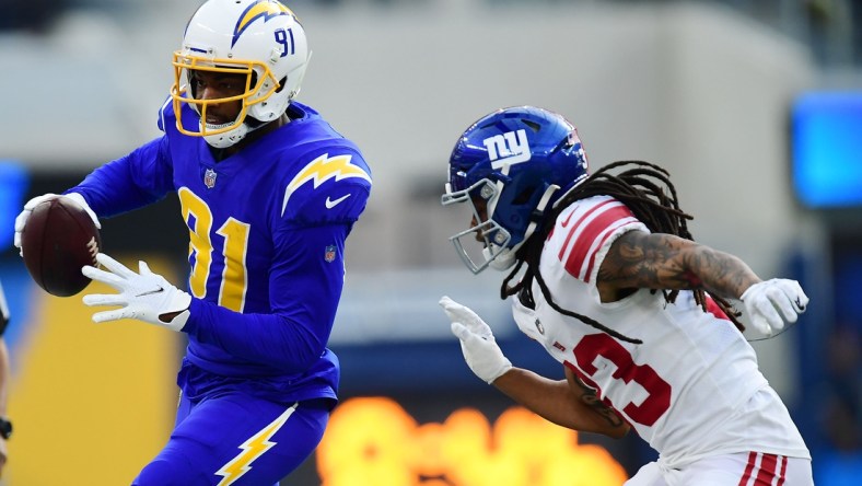 Dec 12, 2021; Inglewood, California, USA; Los Angeles Chargers wide receiver Mike Williams (81) runs the ball ahead of New York Giants safety Logan Ryan (23) during the first half at SoFi Stadium. Mandatory Credit: Gary A. Vasquez-USA TODAY Sports