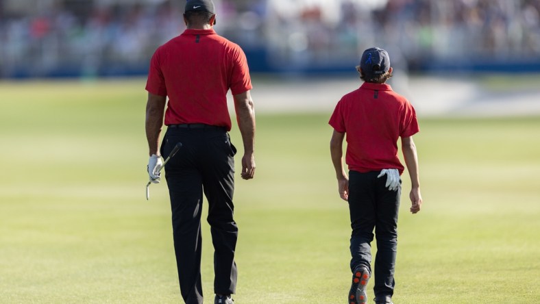 Dec 19, 2021; Orlando, Florida, USA; Tiger Woods and his son Charlie Woods walking down the 18th fairway during the final round of the PNC Championship golf tournament at Grande Lakes Orlando Course. Mandatory Credit: Jeremy Reper-USA TODAY Sports