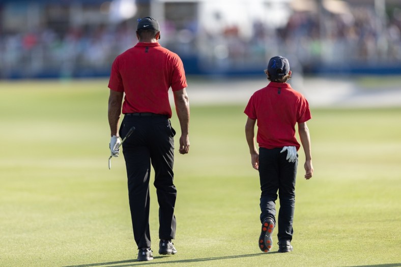 Dec 19, 2021; Orlando, Florida, USA; Tiger Woods and his son Charlie Woods walking down the 18th fairway during the final round of the PNC Championship golf tournament at Grande Lakes Orlando Course. Mandatory Credit: Jeremy Reper-USA TODAY Sports