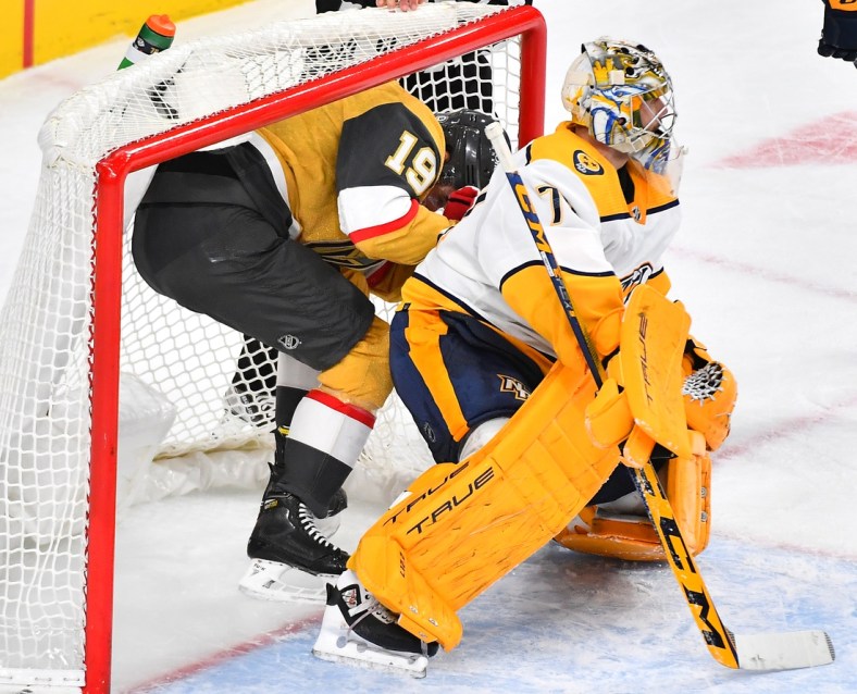 Jan 4, 2022; Las Vegas, Nevada, USA; Vegas Golden Knights right wing Reilly Smith (19) is inside the net behind Nashville Predators goaltender Juuse Saros (74) during the third period at T-Mobile Arena. Mandatory Credit: Stephen R. Sylvanie-USA TODAY Sports