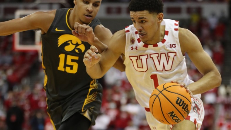 Jan 6, 2022; Madison, Wisconsin, USA; Wisconsin Badgers guard Johnny Davis (1) brings the ball up the floor as Iowa Hawkeyes forward Keegan Murray (15) follows at the Kohl Center. Mandatory Credit: Mary Langenfeld-USA TODAY Sports